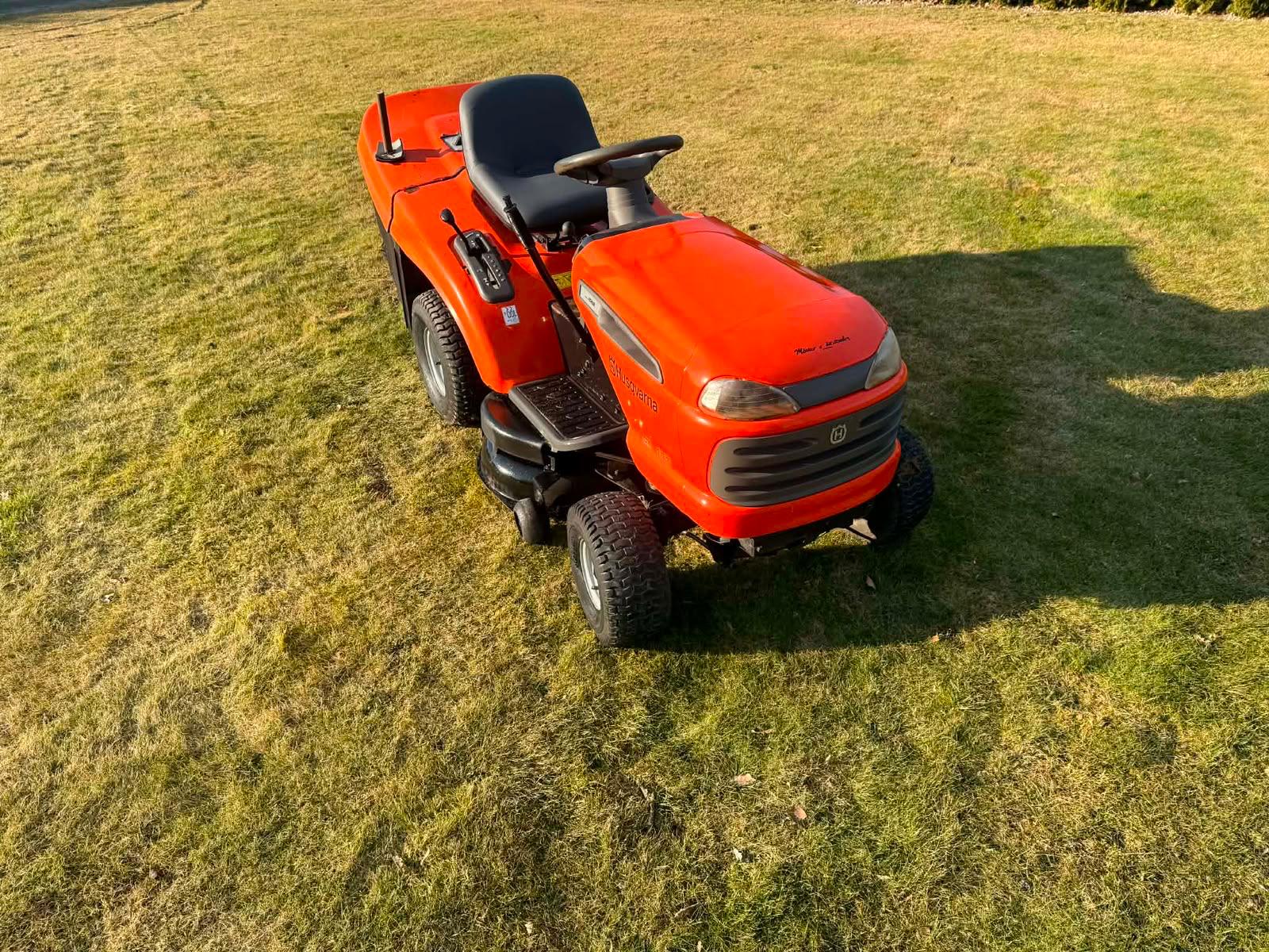 Pomarańczowy traktorek ogrodowy Husqvarna na trawniku